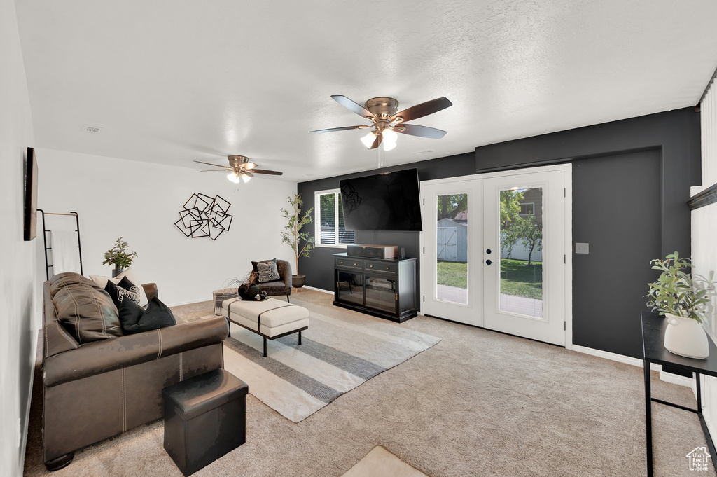 Living room featuring french doors, a ceiling fan, light colored carpet, and baseboards