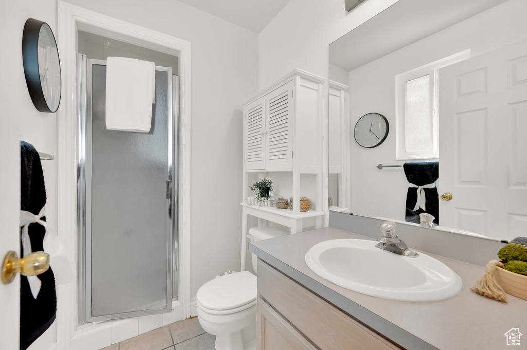 Bathroom featuring a stall shower, vanity, toilet, and tile patterned floors