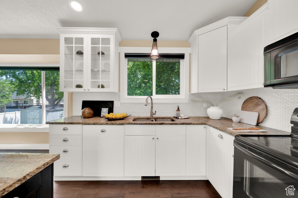 Kitchen featuring black appliances, a sink, stone counters, tasteful backsplash, and recessed lighting