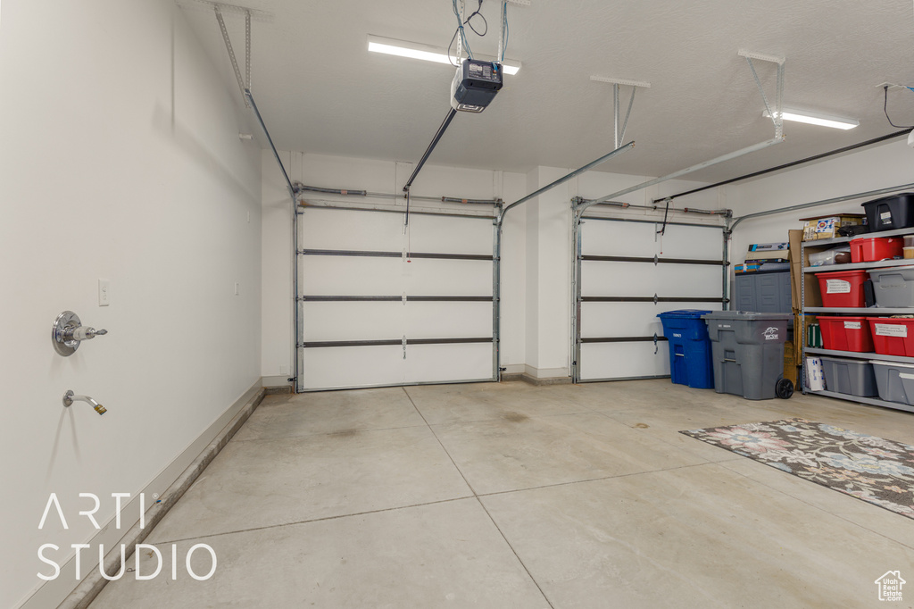 Garage with a garage door opener and baseboards