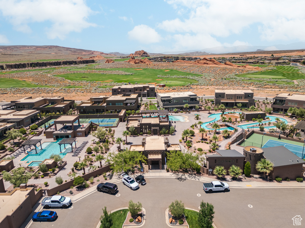 Drone / aerial view of a pool, mountains, and a golf club