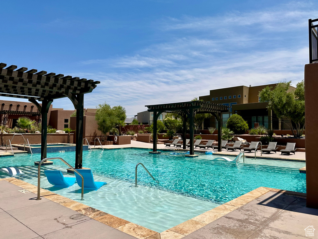 Community pool featuring a pergola and a patio