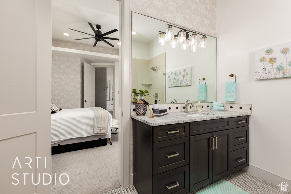 Bathroom featuring vanity, a ceiling fan, wallpapered walls, a walk in shower, and ensuite bathroom