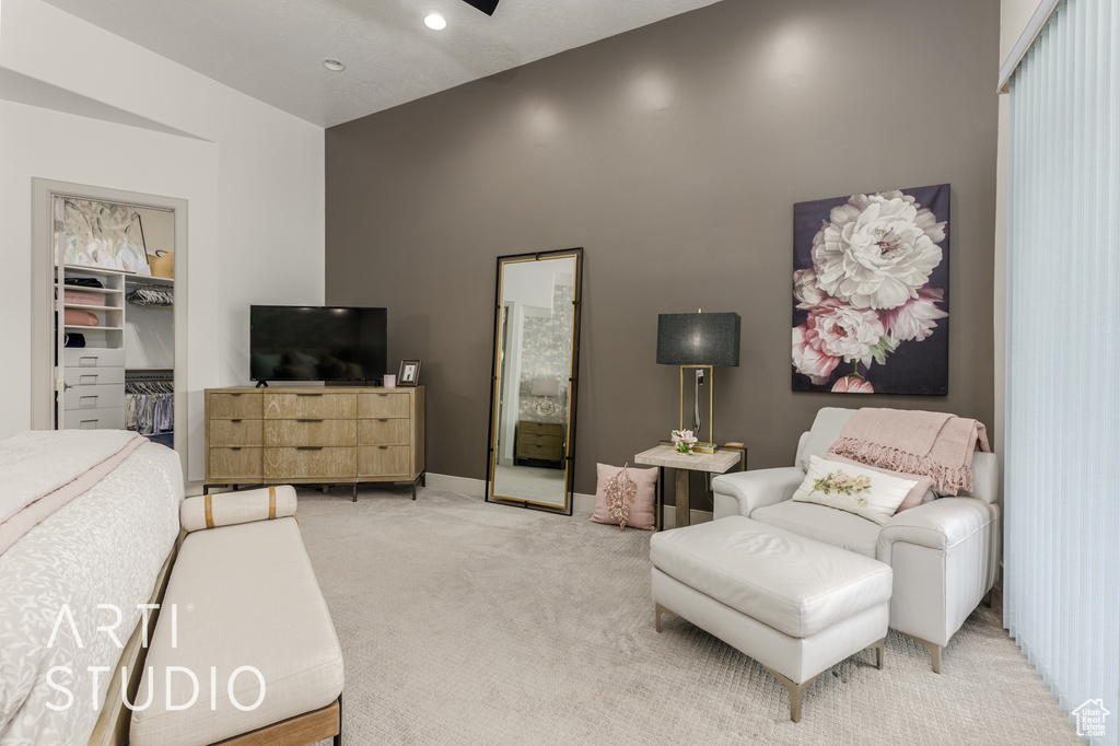 Bedroom featuring light carpet and a walk in closet