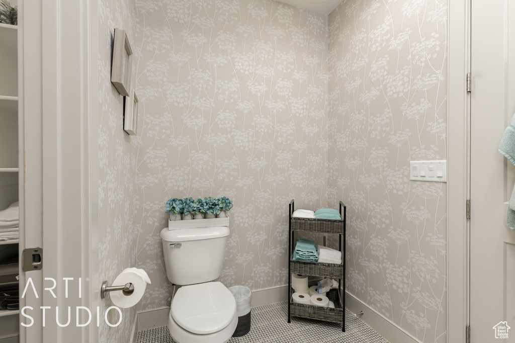 Bathroom featuring toilet, tile patterned floors, and baseboards