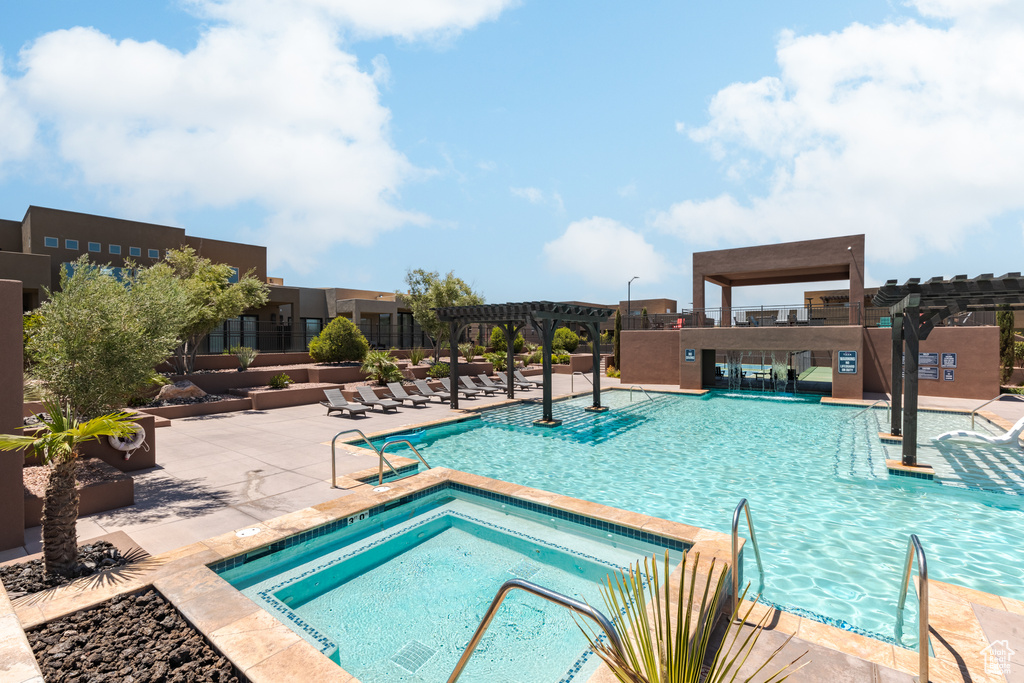 Community pool featuring a pergola, a hot tub, and a patio area