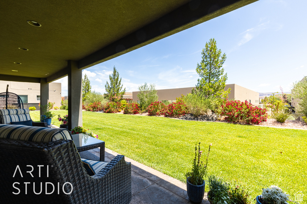 View of grassy yard featuring a patio
