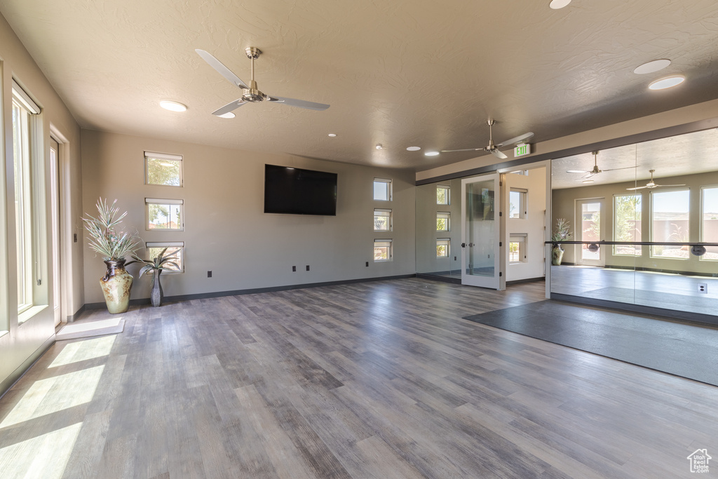 Unfurnished living room with a ceiling fan, wood finished floors, recessed lighting, and baseboards