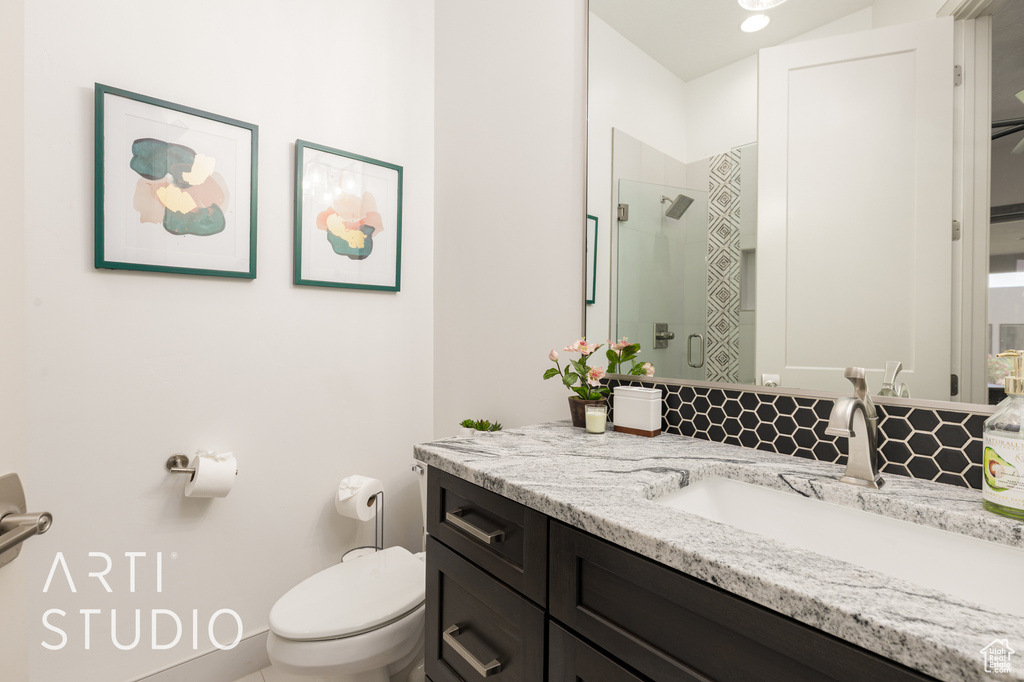 Full bathroom with toilet, vanity, and a shower with shower door