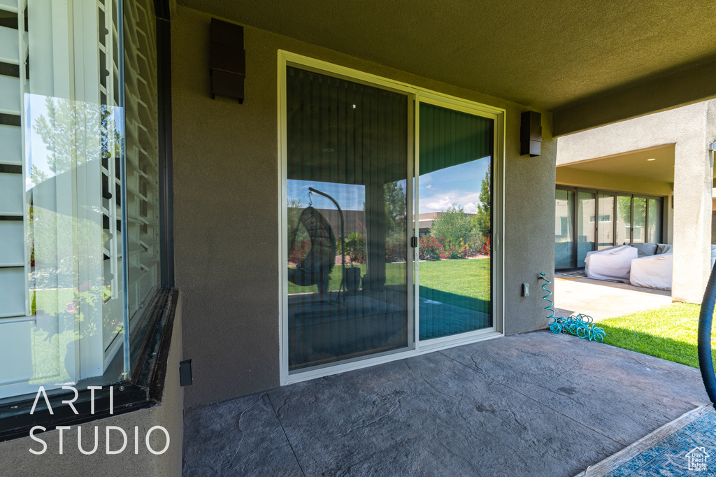 Entrance to property with a patio area and stucco siding