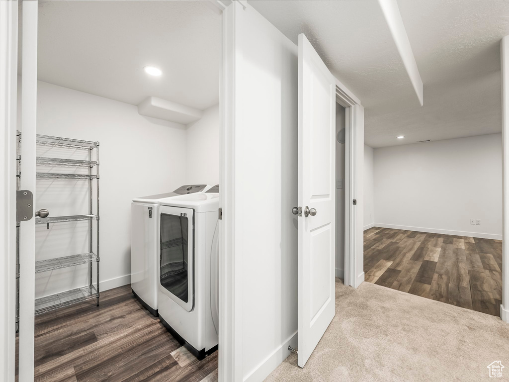 Washroom with washing machine and clothes dryer, baseboards, wood finished floors, and recessed lighting