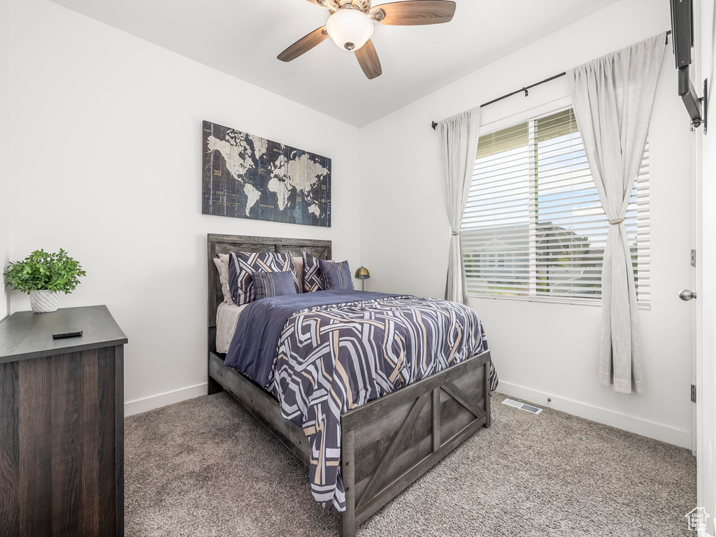 Bedroom featuring baseboards, carpet flooring, and ceiling fan