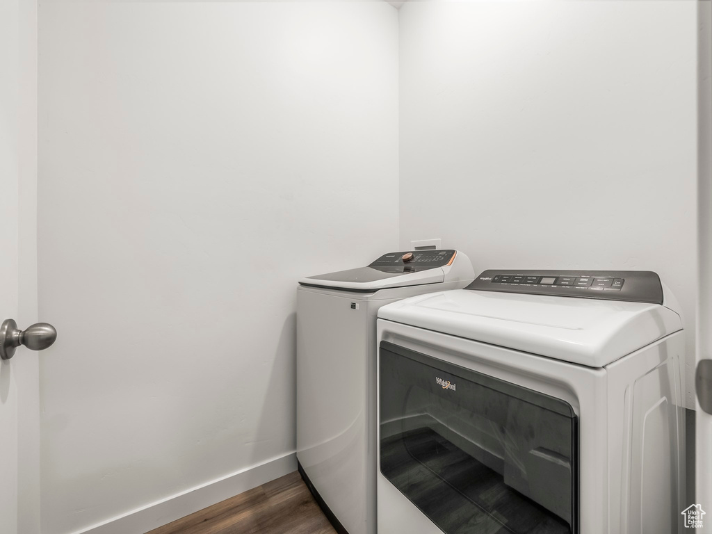 Laundry area featuring washer and dryer, dark wood-type flooring, and baseboards