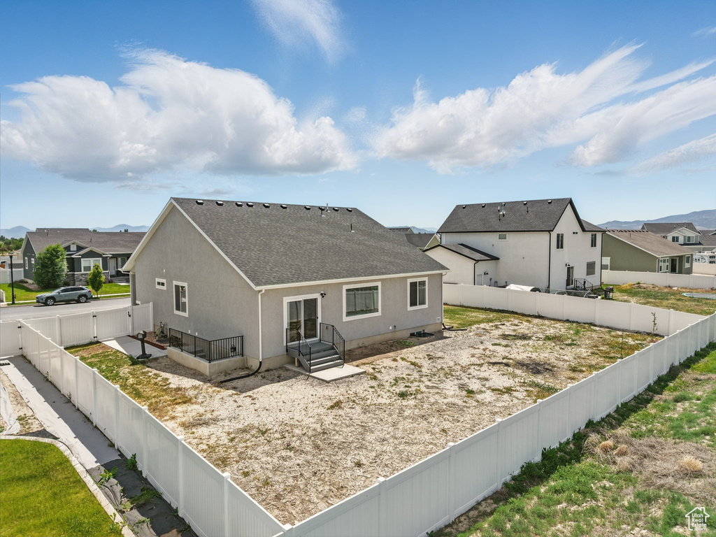 Back of property featuring a shingled roof, a residential view, and a fenced backyard