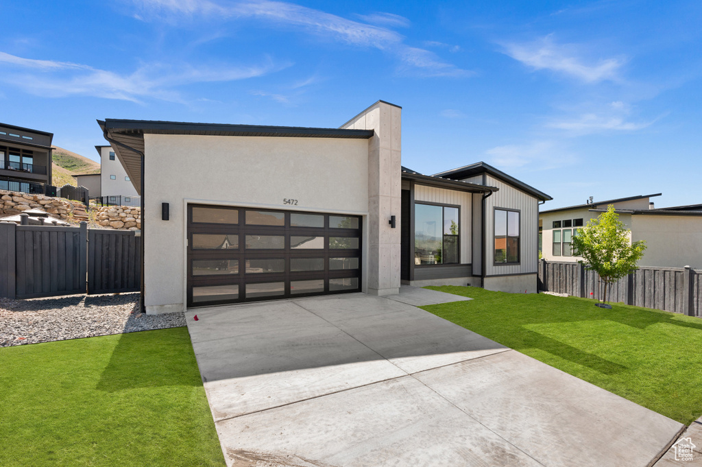 Contemporary house with concrete driveway and an attached garage