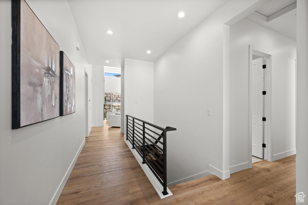 Corridor featuring an upstairs landing, light wood-style flooring, baseboards, and recessed lighting
