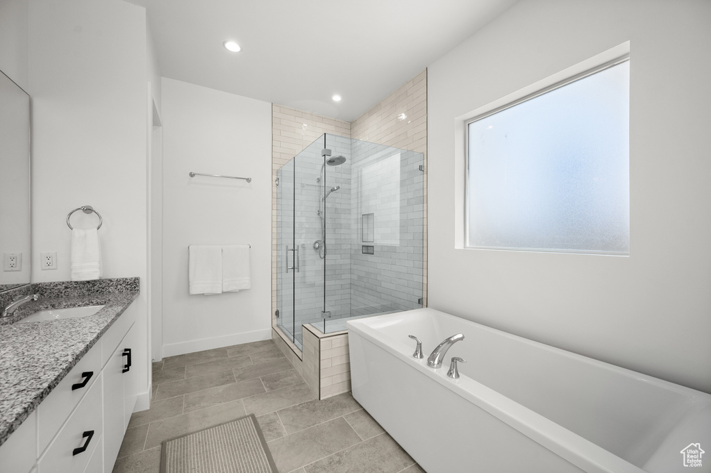 Full bathroom featuring a stall shower, vanity, a bathtub, recessed lighting, and baseboards