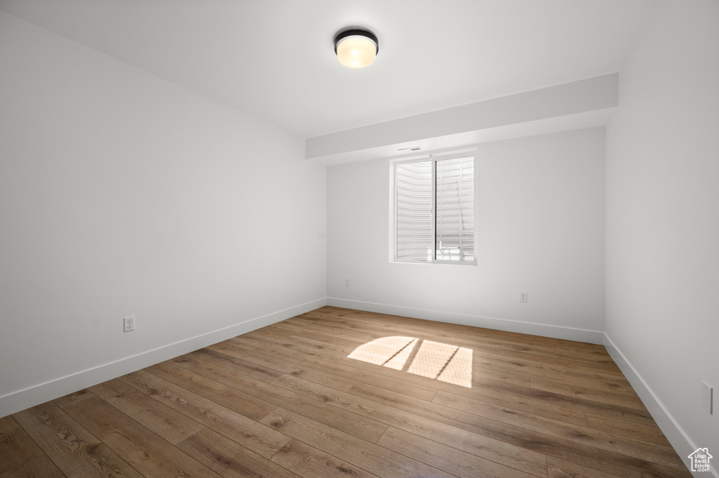Spare room featuring baseboards and wood finished floors
