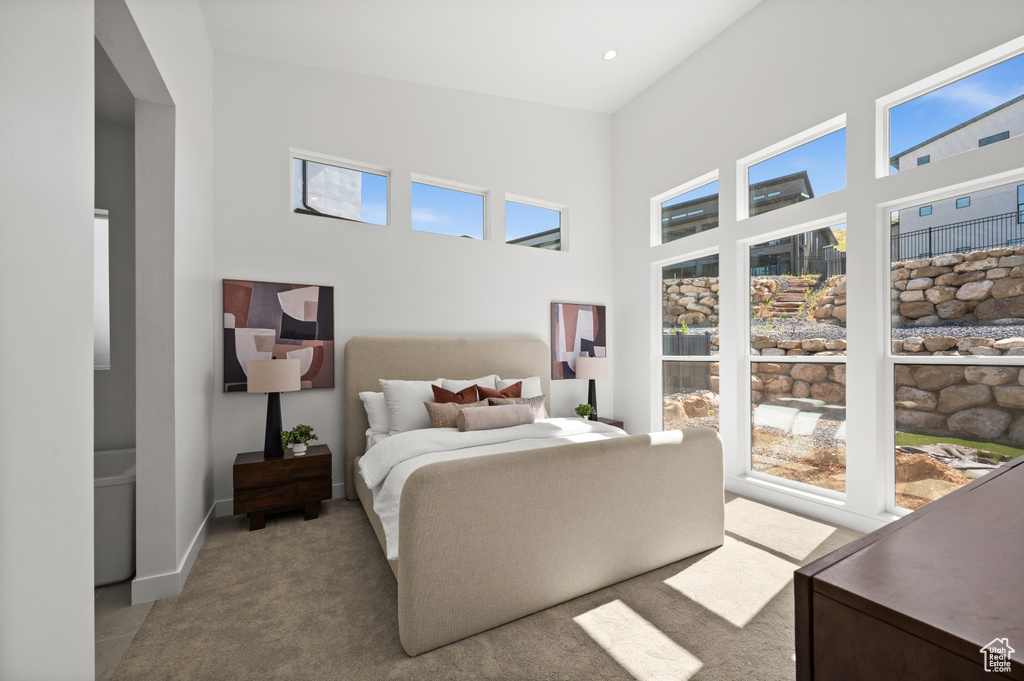 Bedroom featuring a towering ceiling and carpet