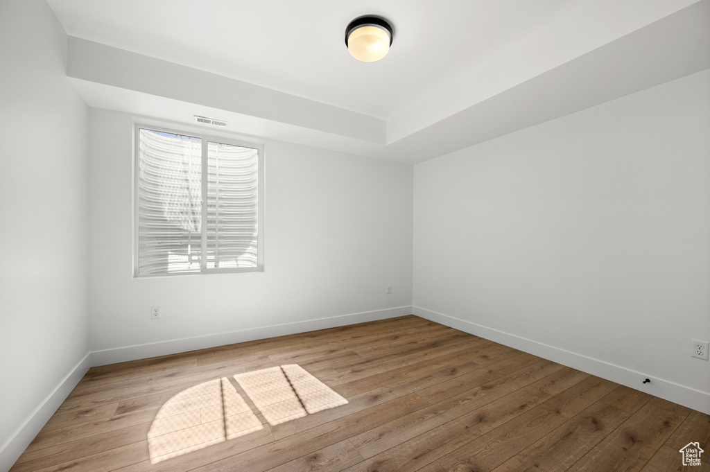 Unfurnished room with wood finished floors and baseboards