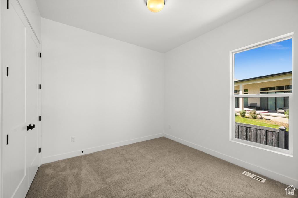Carpeted empty room featuring baseboards