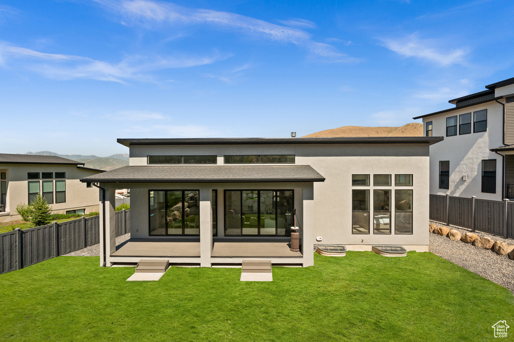 Rear view of house featuring stucco siding and a shingled roof