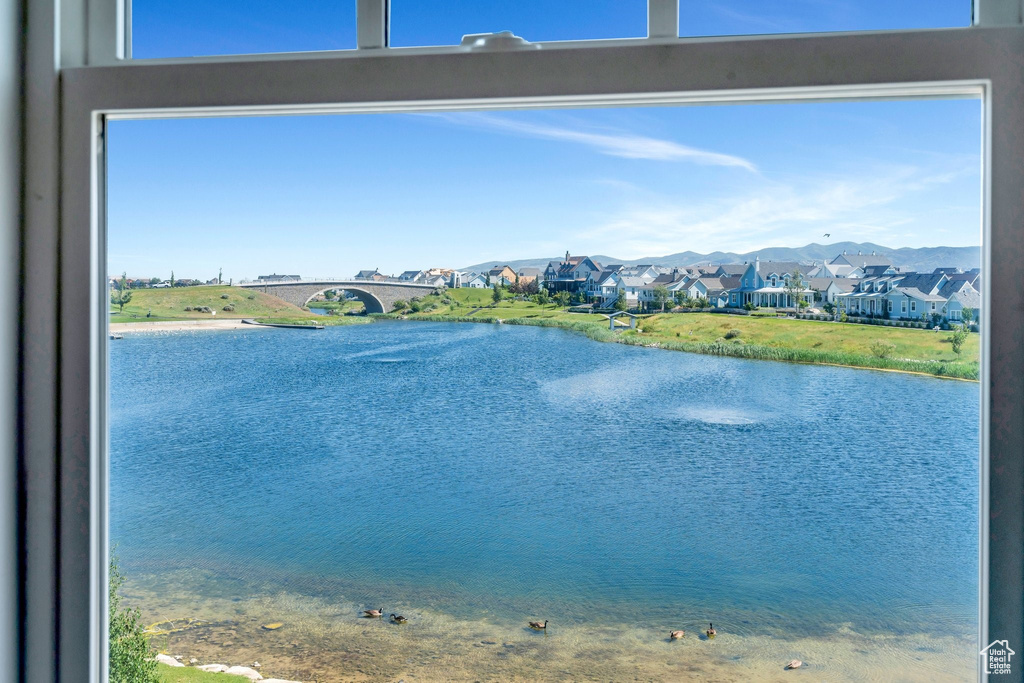 Water view featuring a mountainous background and nearby suburban area