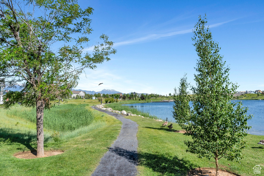 View of community with a water and mountain view and a lawn