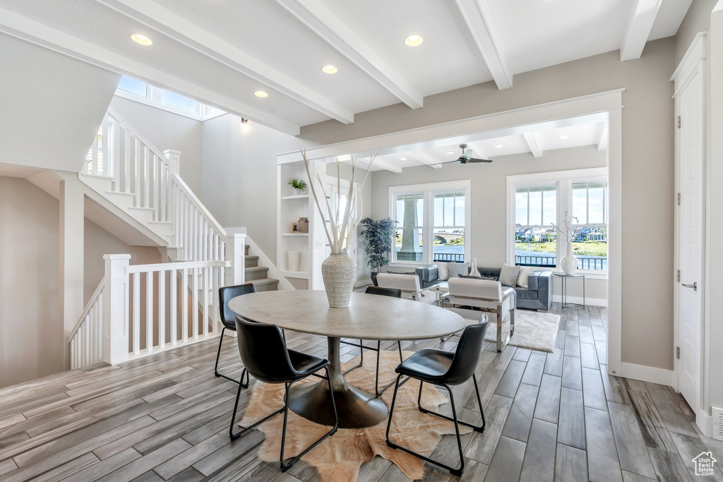 Dining space with wood finish floors, beam ceiling, recessed lighting, stairs, and baseboards