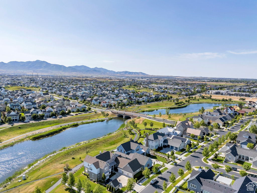 Aerial view of property's location featuring a water and mountain view and nearby suburban area