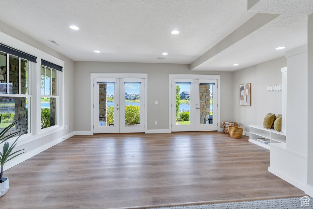 Doorway featuring healthy amount of natural light, french doors, recessed lighting, and wood finished floors