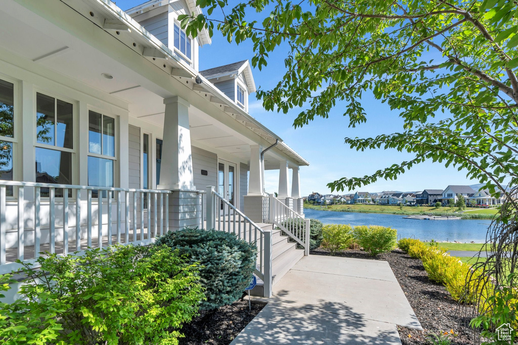 Doorway to property with covered porch and a water view