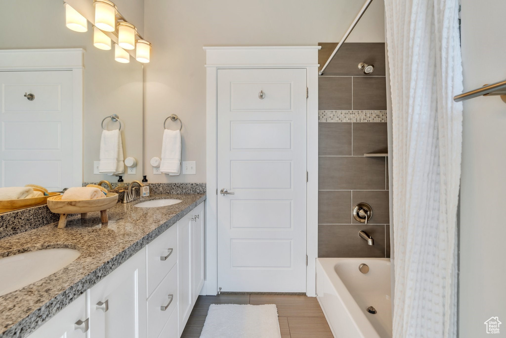 Full bath with shower / tub combo with curtain, double vanity, and tile patterned floors