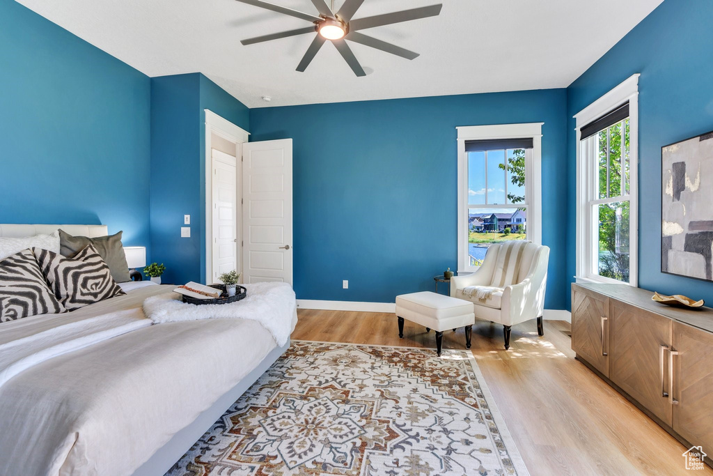Bedroom with light wood-style flooring, baseboards, and a ceiling fan