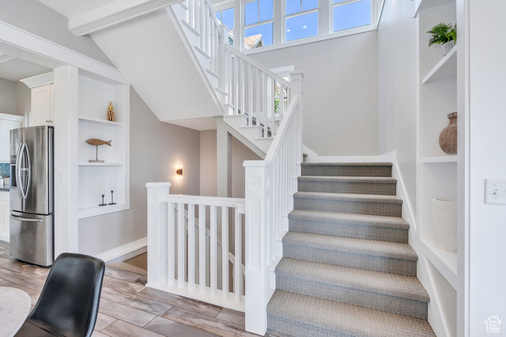Stairs featuring built in features and wood finished floors