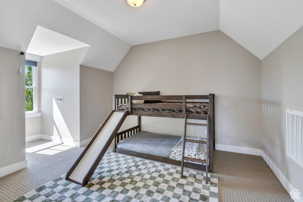 Bedroom with carpet flooring, vaulted ceiling, and baseboards