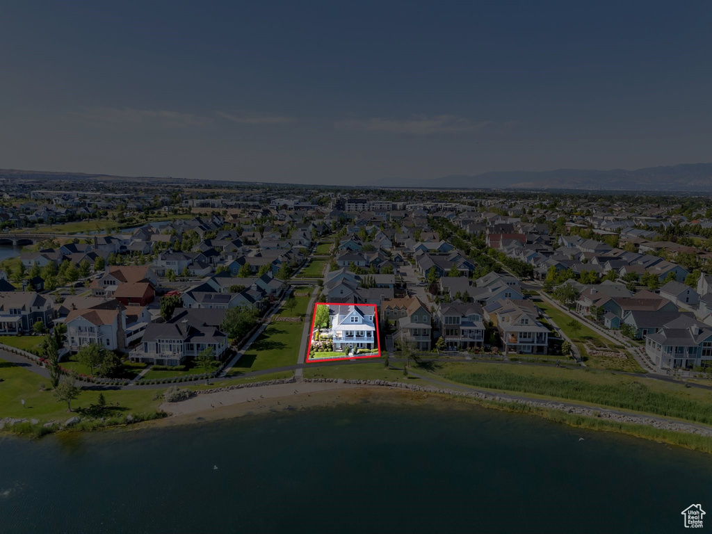 Aerial overview of property's location featuring a large body of water, property parcel outlined, and nearby suburban area