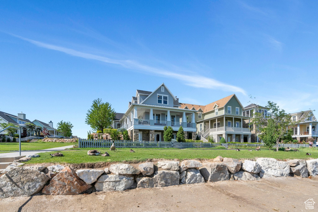 View of front of home featuring stone siding and a balcony