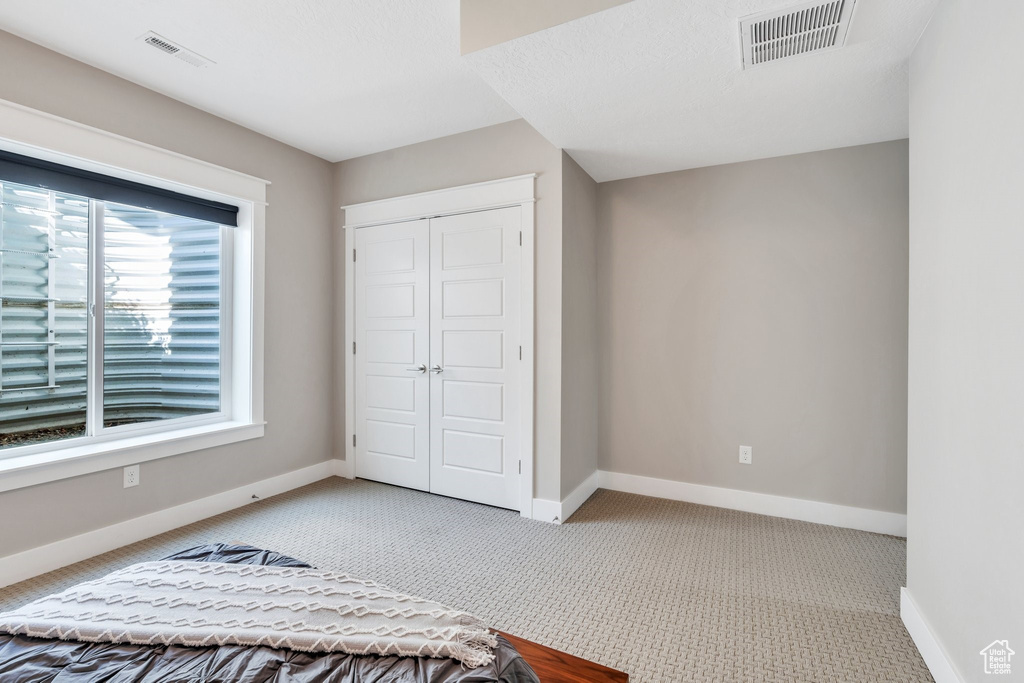 Unfurnished bedroom featuring carpet floors, a closet, and baseboards