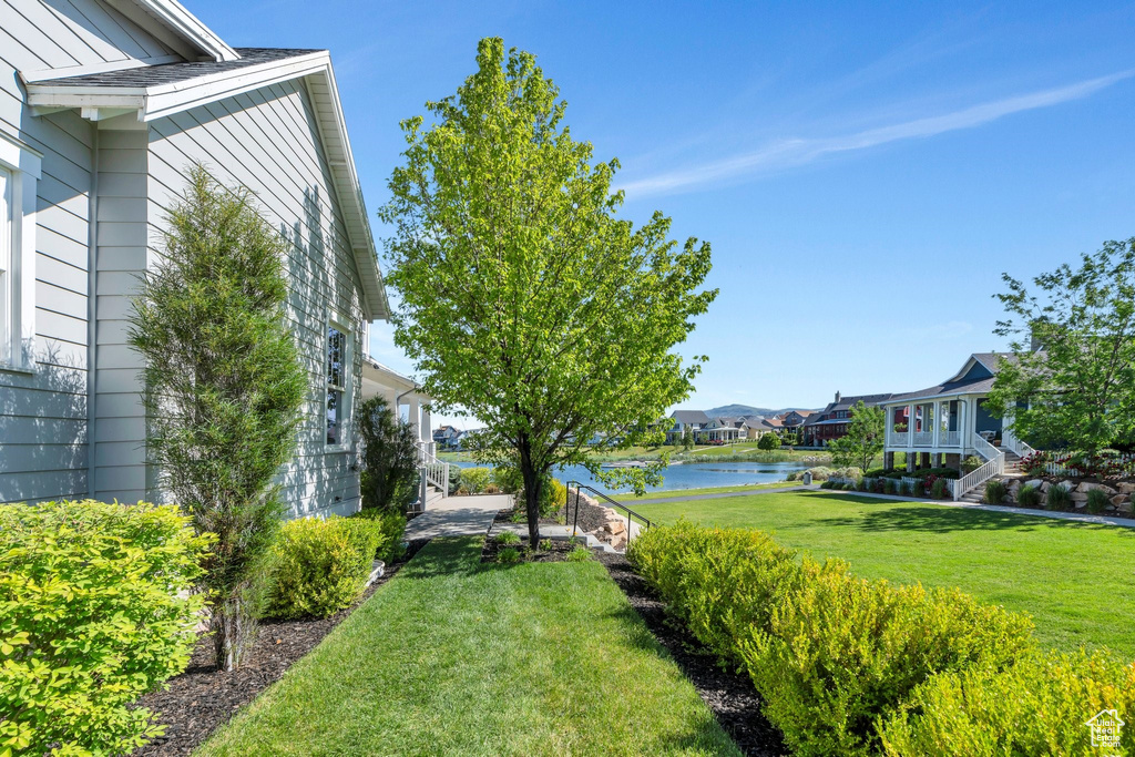 View of grassy yard with a water view and a residential view