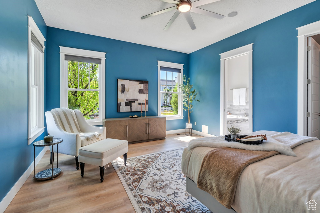 Bedroom featuring baseboards, multiple windows, wood finished floors, and a ceiling fan