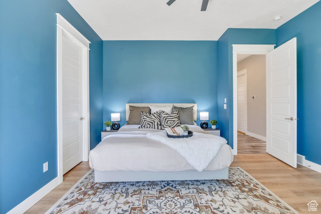Bedroom featuring baseboards, wood finished floors, and ceiling fan