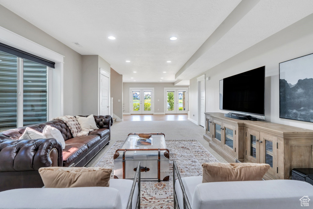 Living room with baseboards, recessed lighting, and light carpet