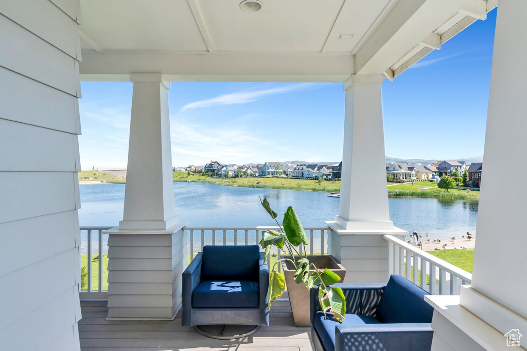 Covered porch featuring a water view and a residential view