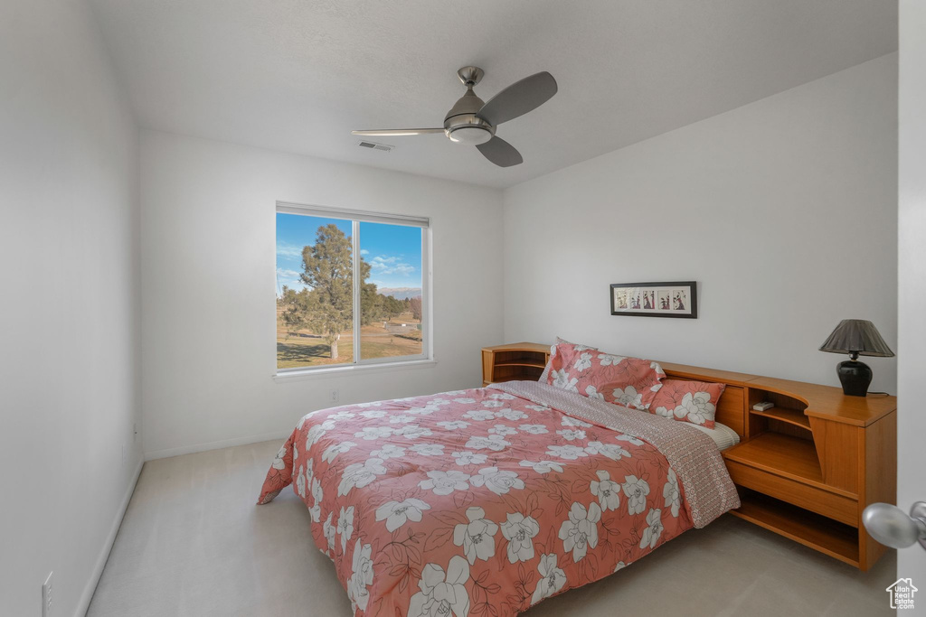Carpeted bedroom with baseboards and a ceiling fan
