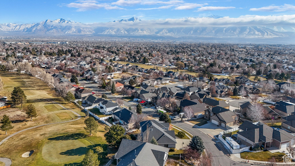 Aerial view of property and surrounding area with nearby suburban area and mountains