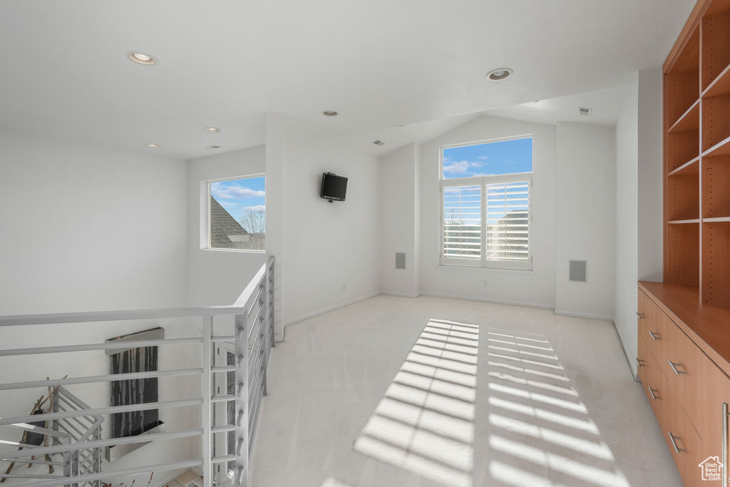 Empty room with light colored carpet, recessed lighting, lofted ceiling, and baseboards