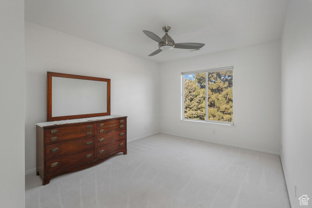 Bedroom featuring light carpet, ceiling fan, and baseboards