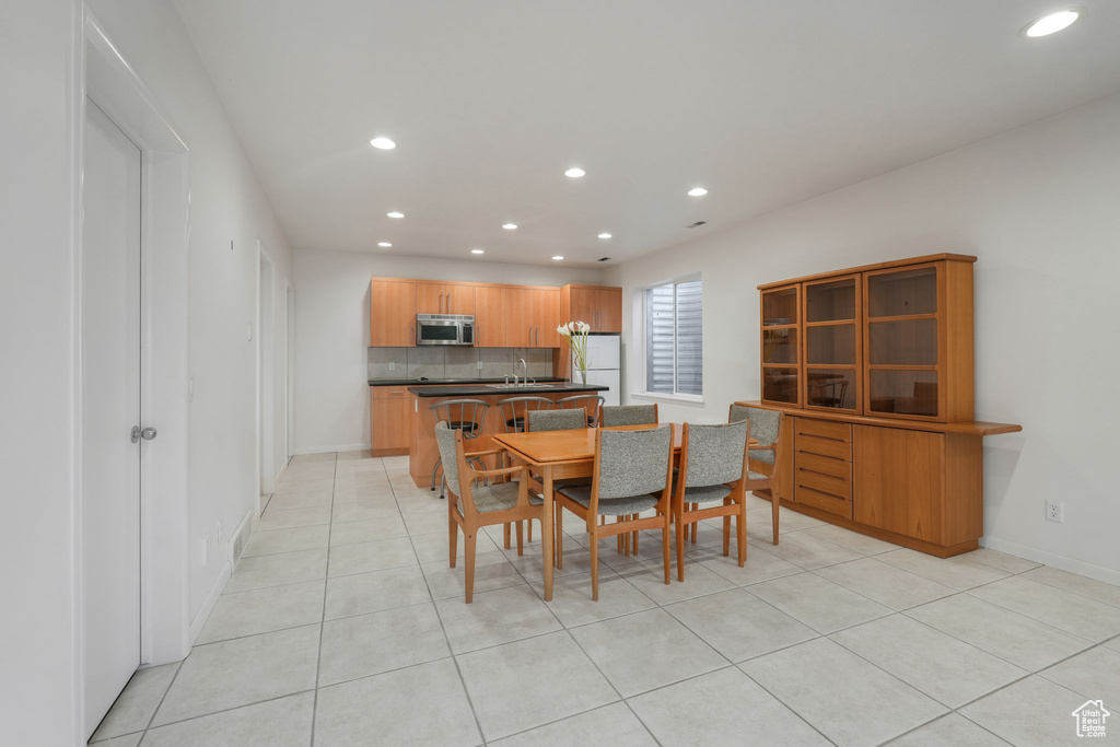 Dining space featuring recessed lighting, light tile patterned flooring, and baseboards