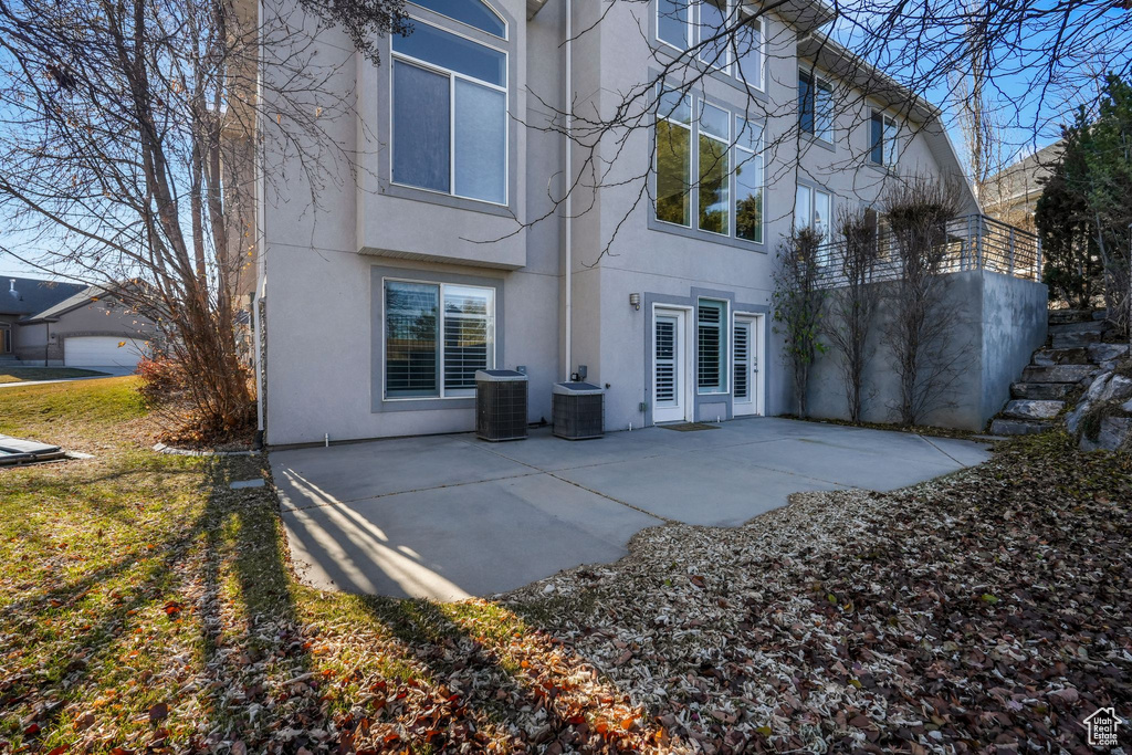 Rear view of property with stucco siding, a patio, and central AC unit
